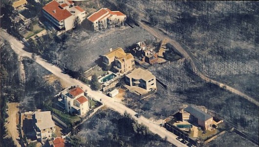 Ο εντός του καμένου δάσους οικισμός. Το δάσος κάηκε, τα σπίτια όχι, αφού το δάσος αφίεται στην τύχη του προκειμένου να προστατευτούν οι οικίες –ας λάβουμε όμως υπόψη μας ότι οι οικίες εγκαταστάθηκαν στο δάσος και δε συνέβη το αντίστροφο! (φωτογραφία από το διαδίκτυο).